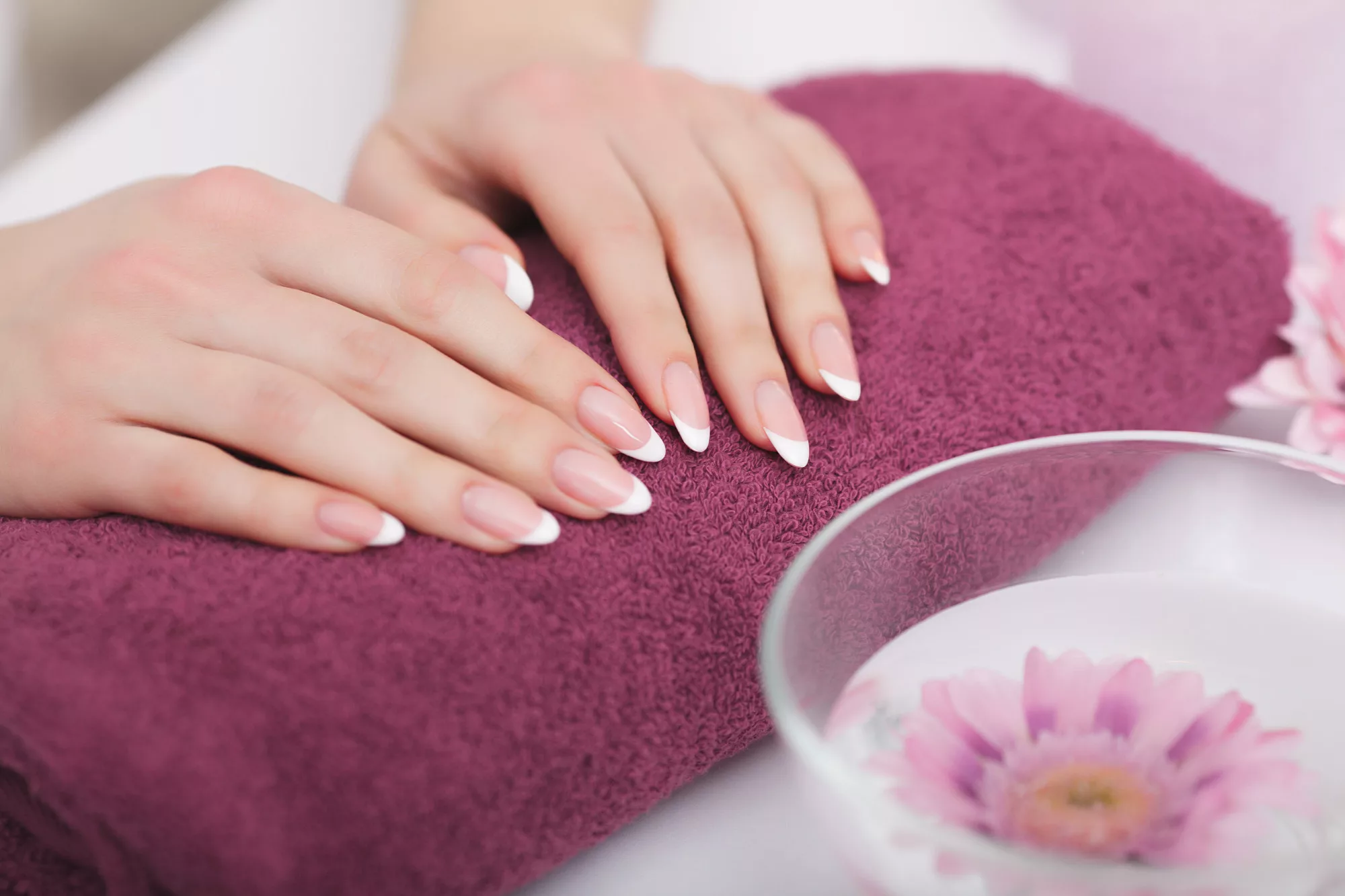 Manos con manicura francesa sobre una toalla